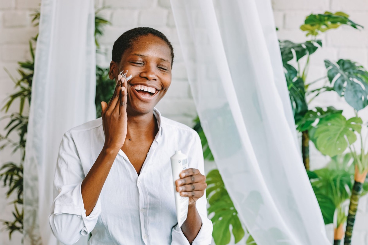 Dermatologista aplicando hidratante em um rosto