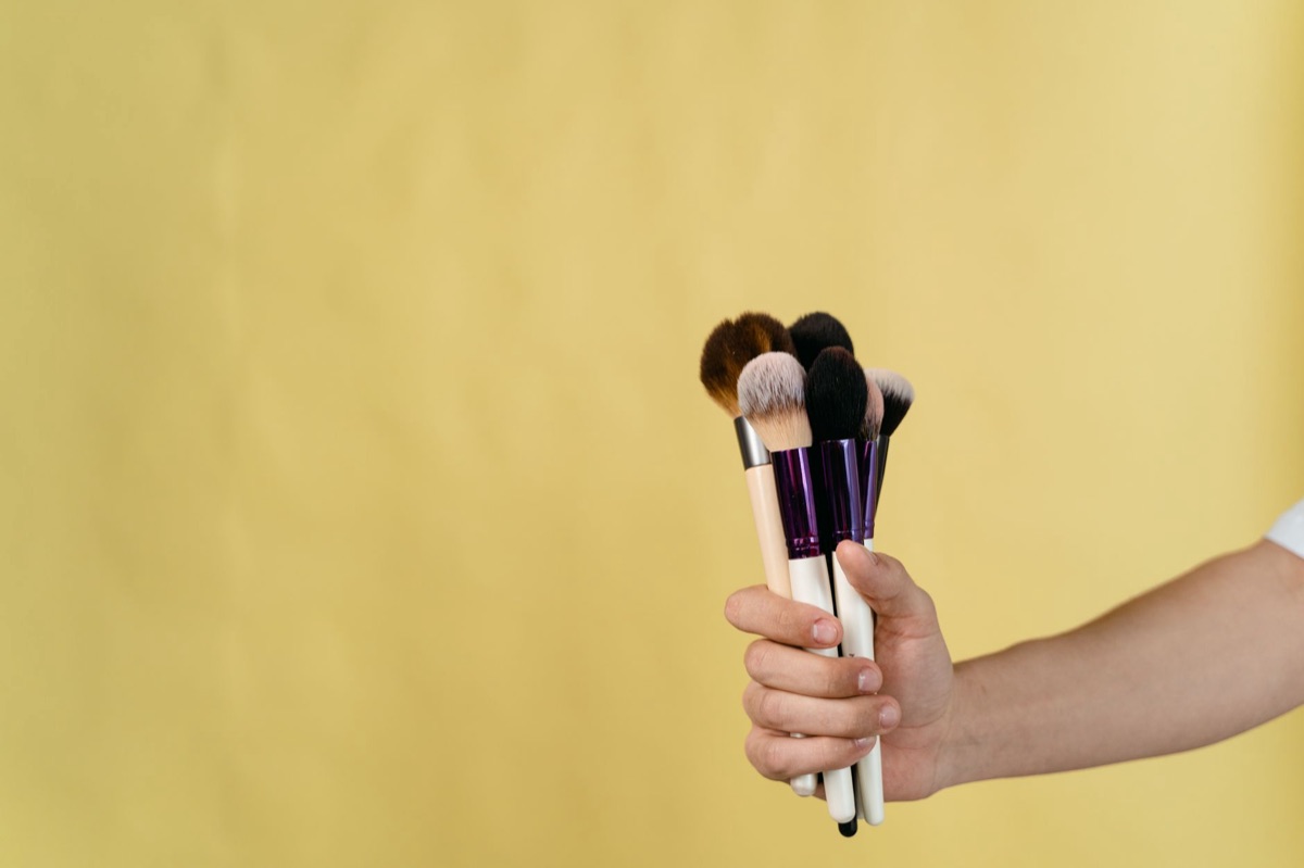 Primer plano de brochas de maquillaje con polvo suave.