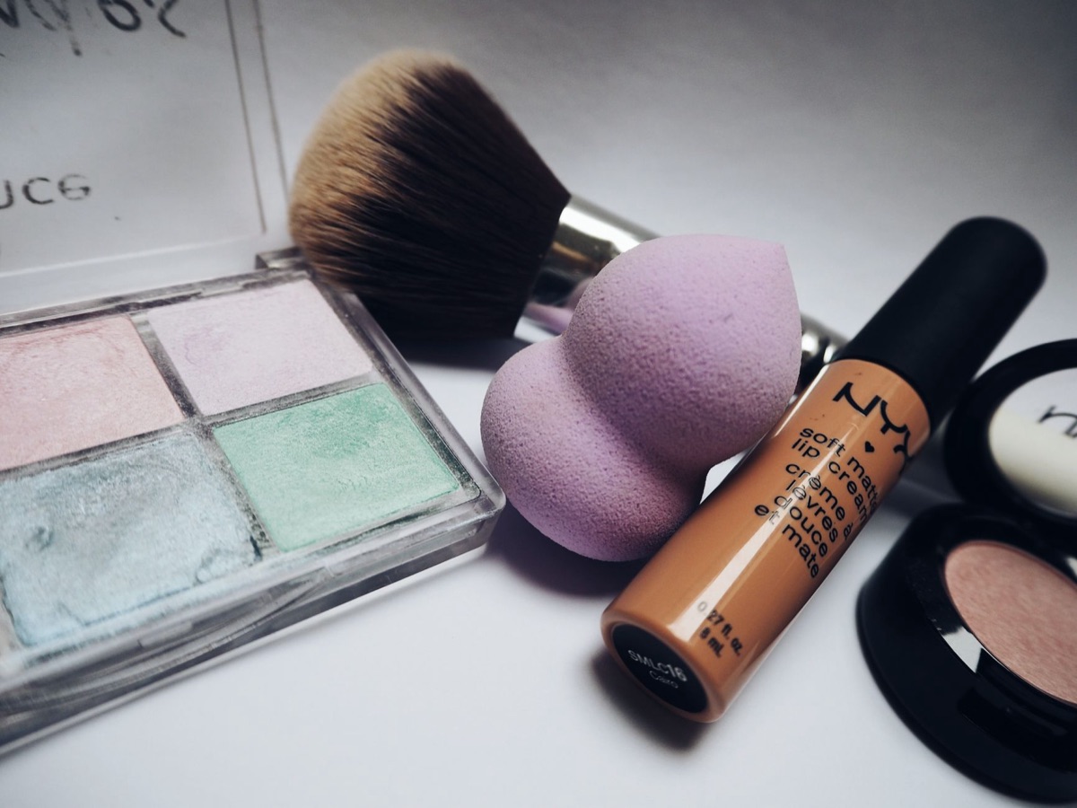 verschillende kleurtesters van lippenstift en oogschaduw op een witte ondergrond